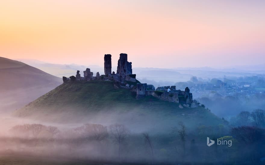 Corfe Castle shrouded in mist at sunrise in Dorset